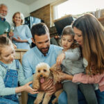 Happy family having enjoying with their dog at home.